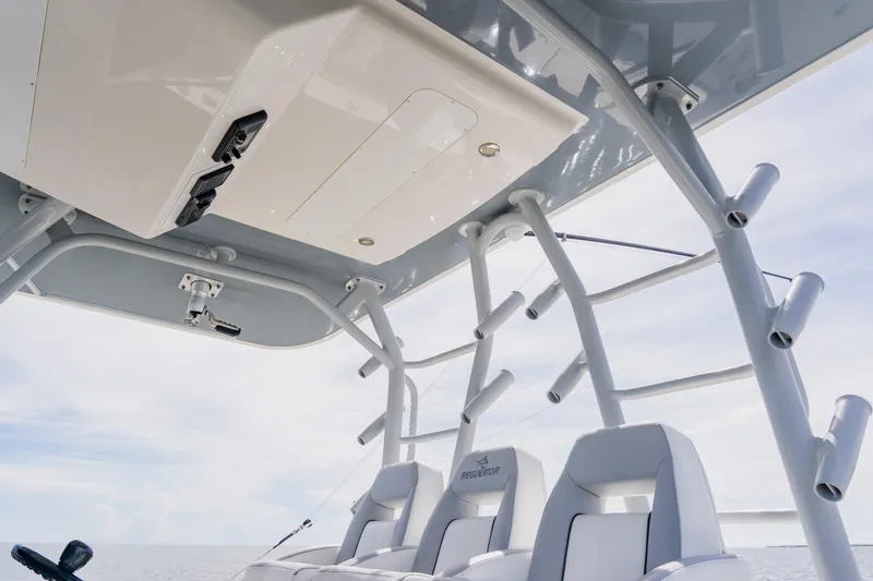 Slide: The Image of 2018 Regulator 41 boat interior with seating and rod holders under a clear sky. - 57