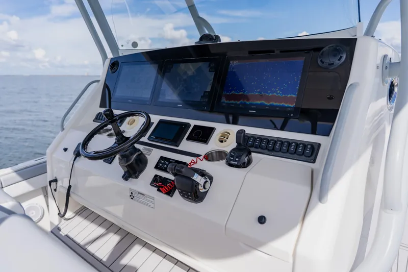 Slide: The Image of Control panel of a 2018 Regulator 41 boat with navigation screens and steering wheel. - 66