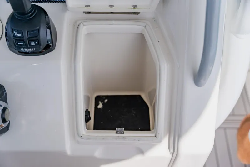 Slide: The Image of Open storage compartment on 2018 Regulator 41 boat console with Yamaha controls. - 67