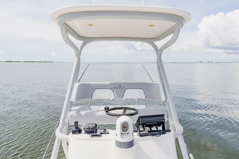 Slide: The Image of 2018 Regulator 41 boat helm with Garmin navigation, on calm waters under a cloudy sky. - 76