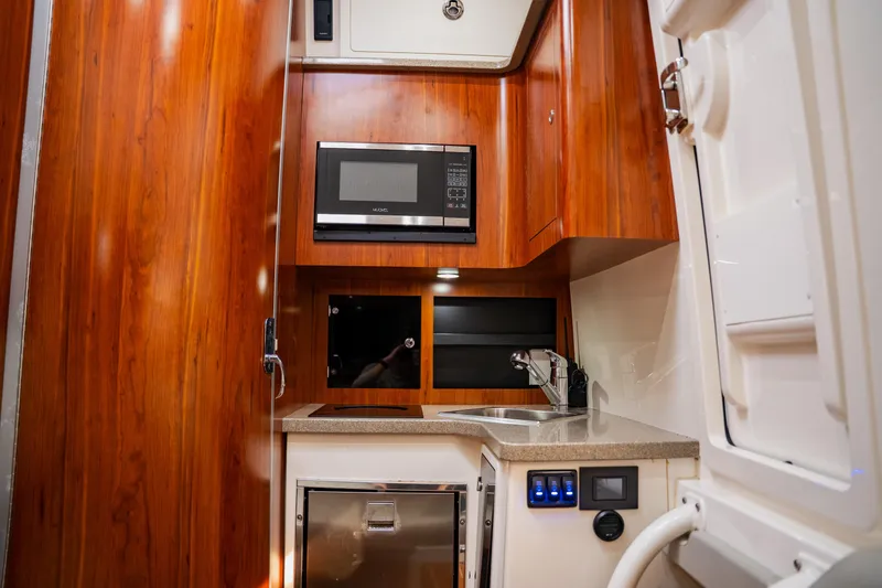 Slide: The Image of Luxurious 2018 Regulator 41 yacht interior with wood finish, kitchenette, and modern amenities. - 84