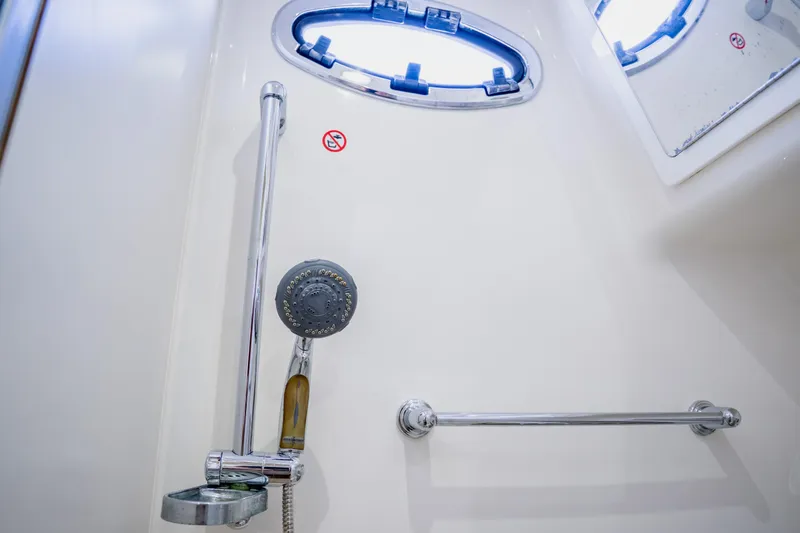 Slide: The Image of Shower area in 2018 Regulator 41 boat with chrome fixtures and porthole window. - 90