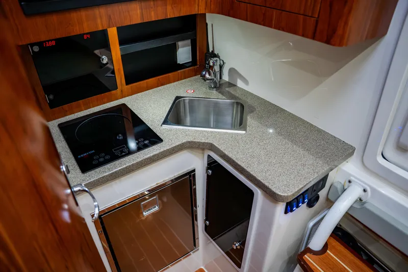 Slide: The Image of 2018 Regulator 41 boat kitchen with sink, stove, and storage cabinets. - 91