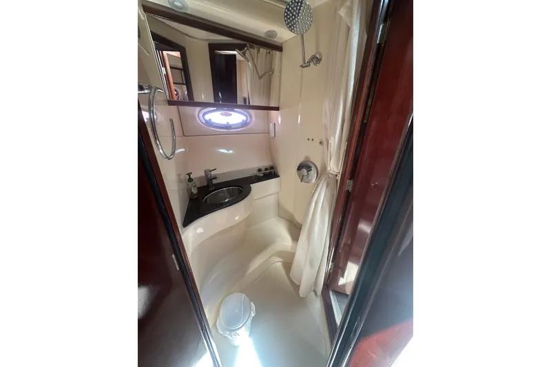 Slide: The Image of 2010 Meridian 391 Sedan yacht bathroom with shower, sink, and porthole window. - 12