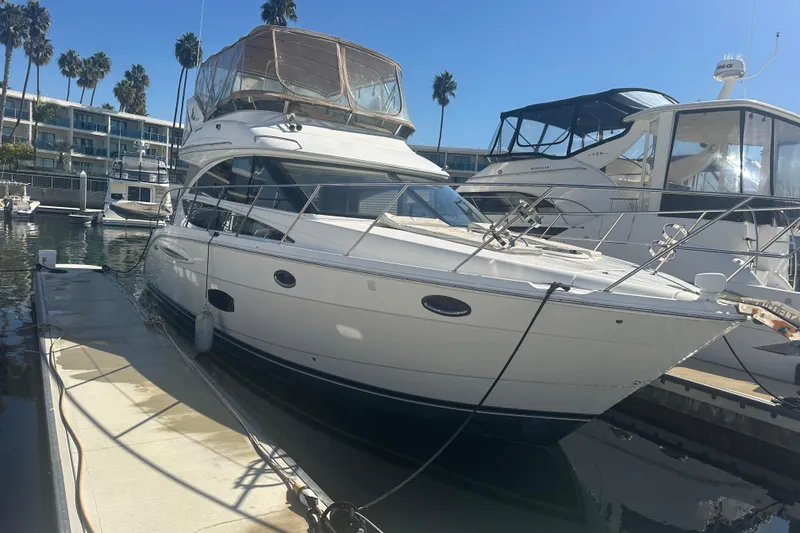 Slide: The Image of 2010 Meridian 391 Sedan yacht docked at marina with palm trees in background. - 2