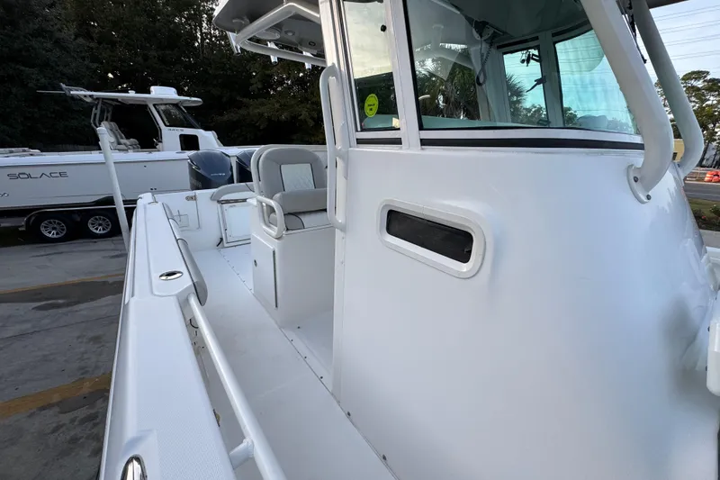 Slide: The Image of 2008 Everglades 290 Center Console boat, white exterior, docked beside another vessel. - 27
