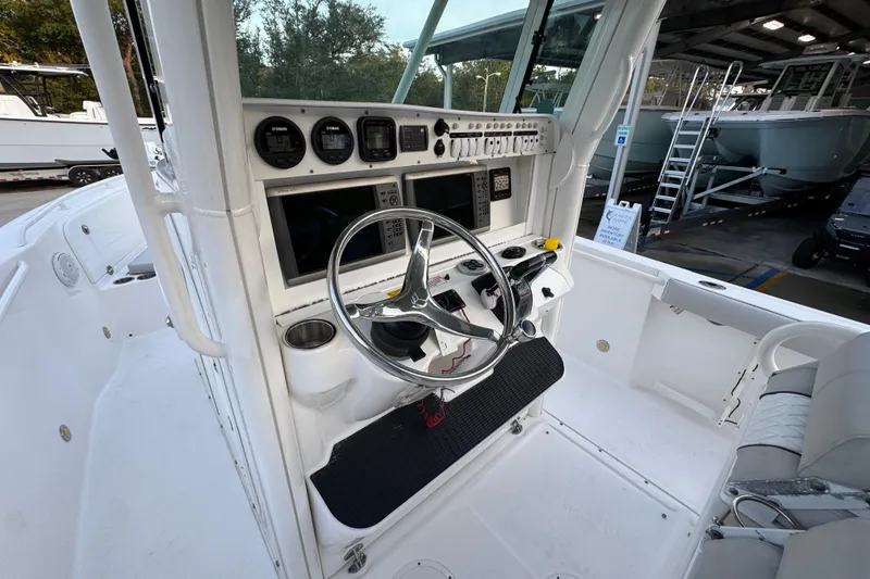 Slide: The Image of 2008 Everglades 290 Center Console boat cockpit with steering wheel and navigation instruments. - 33
