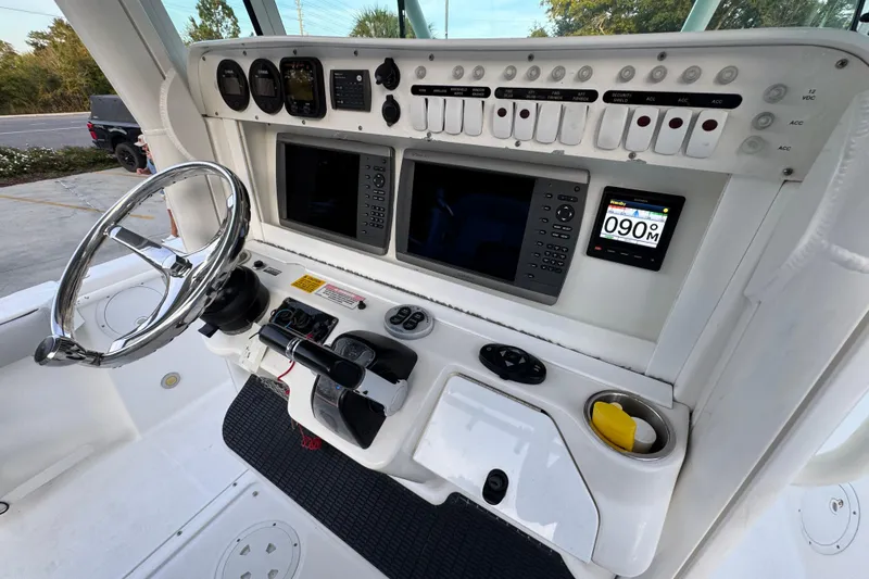 Slide: The Image of 2008 Everglades 290 Center Console boat dashboard with steering wheel and navigation controls. - 36