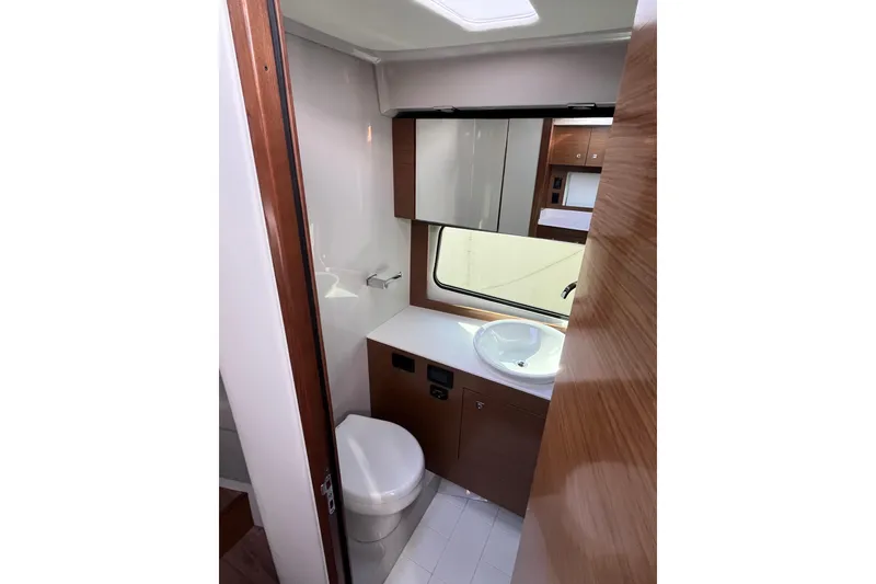 Slide: The Image of 2018 Cruisers Yachts 390 Express Coupe bathroom with modern fixtures and wood accents. - 6