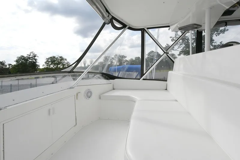Slide: The Image of 1997 Viking 47 Convertible yacht interior with white seating and large windows. - 13
