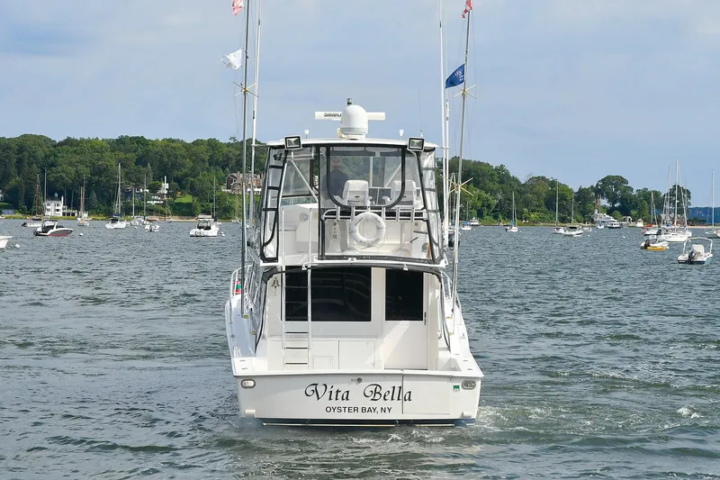 Slide: The Image of 1997 Viking 47 Convertible boat named "Vita Bella" on a scenic waterway. - 2