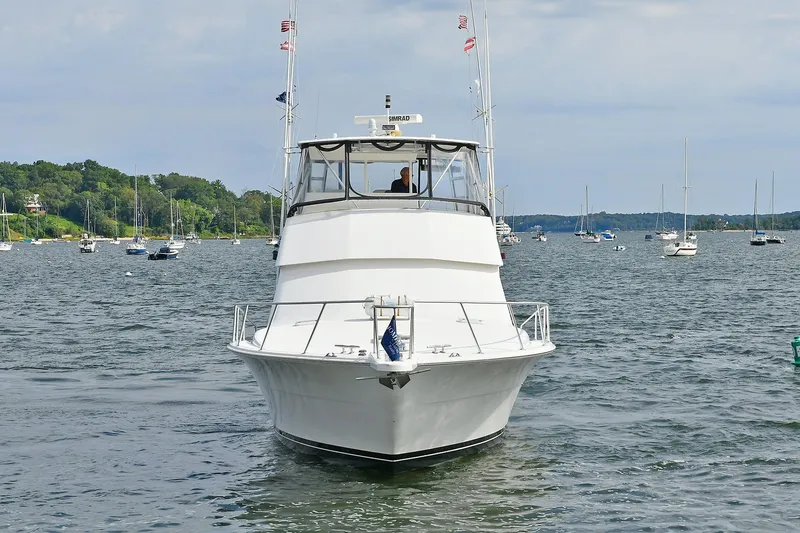 Slide: The Image of 1997 Viking 47 Convertible yacht on a scenic lake with sailboats in the background. - 5