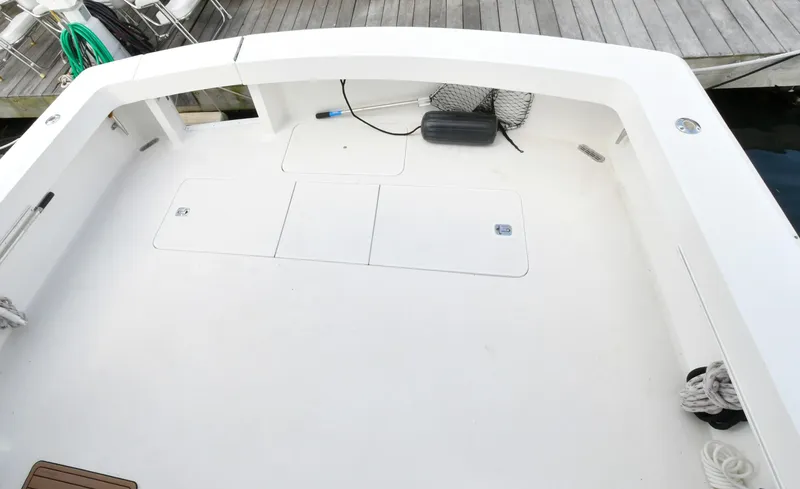 Slide: The Image of 1997 Viking 47 Convertible boat deck with storage hatches and dockside view. - 8