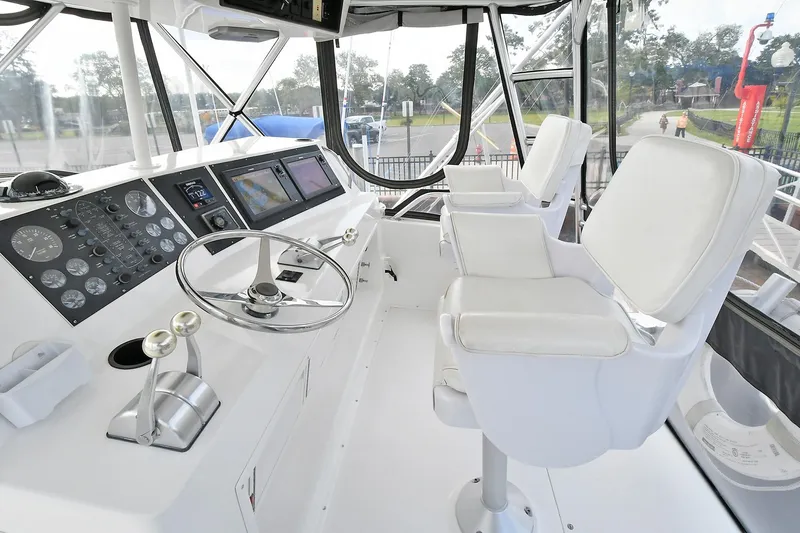 Slide: The Image of Interior of a 1997 Viking 47 Convertible yacht with white helm and seating. - 9