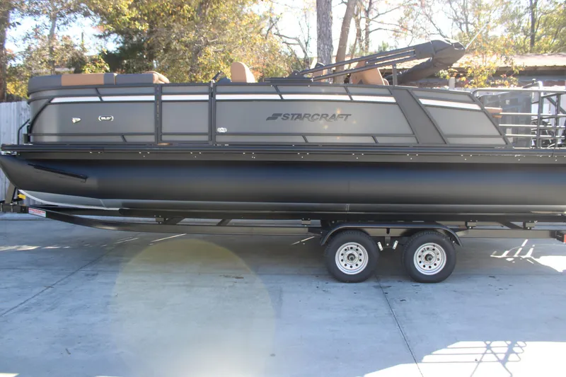 The Image of 2026 Starcraft SLS 3 RL pontoon boat on trailer, parked outdoors. - 1