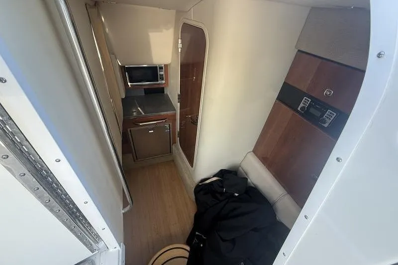 Slide: The Image of Interior of 2015 Formula 350 Crossover Bowrider, featuring compact kitchen and seating area. - 16