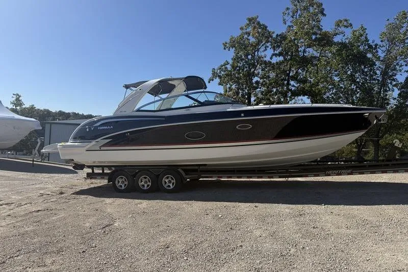 Slide: The Image of 2015 Formula 350 Crossover Bowrider on trailer, parked outdoors under clear sky. - 3
