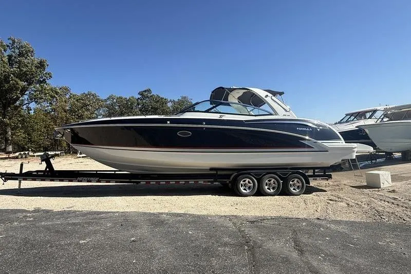 Slide: The Image of 2015 Formula 350 Crossover Bowrider on trailer, parked outdoors under clear sky. - 4