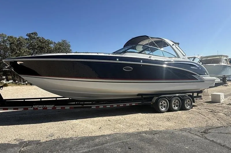 Slide: The Image of 2015 Formula 350 Crossover Bowrider on trailer, parked outdoors under clear sky. - 8