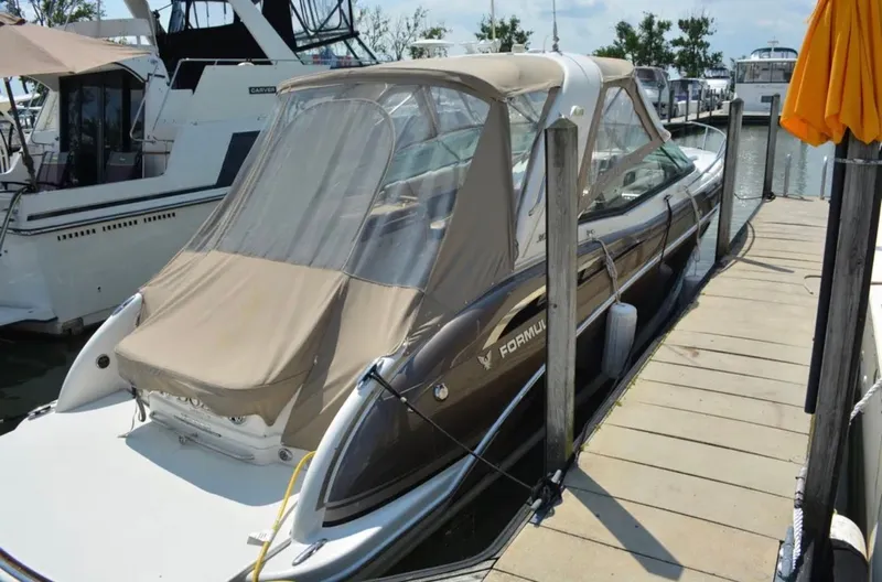 Slide: The Image of 2015 Formula 310 Sun Sport boat docked with beige canopy cover. - 2