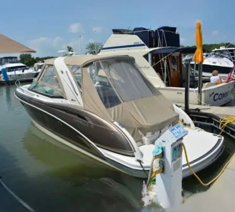 Slide: The Image of 2015 Formula 310 Sun Sport boat docked in a marina, featuring sleek design and beige canopy. - 3