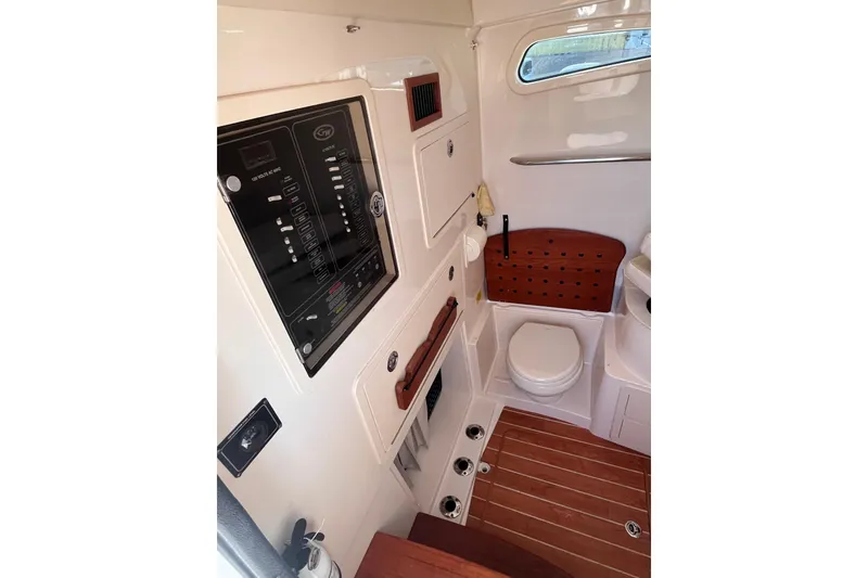 Slide: The Image of 2022 Grady-White Canyon 336 boat interior with control panel and compact bathroom. - 7