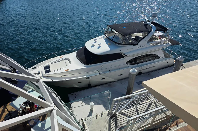 Slide: The Image of 2005 Meridian 580 Pilothouse yacht docked near waterfront restaurant with glass dome. - 4