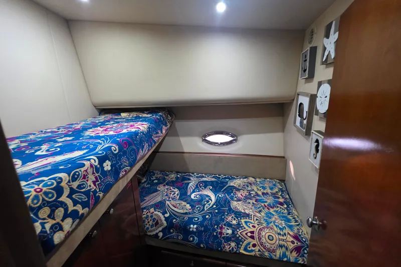 Slide: The Image of 2005 Meridian 580 Pilothouse cabin with vibrant patterned bedding and wooden cabinetry. - 41