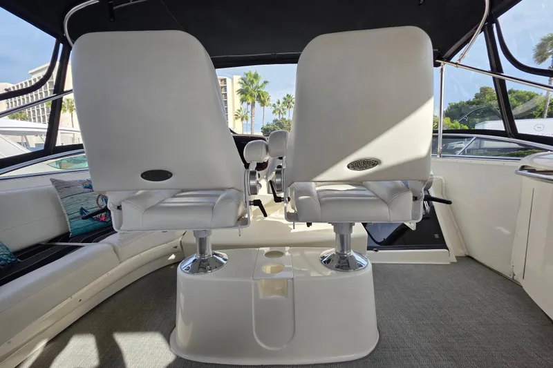 Slide: The Image of 2005 Meridian 580 Pilothouse interior with TV and mini fridge, docked near greenery. - 49