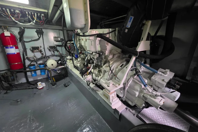 Slide: The Image of Engine room of 2005 Meridian 580 Pilothouse yacht, featuring mechanical components and fire extinguisher. - 77