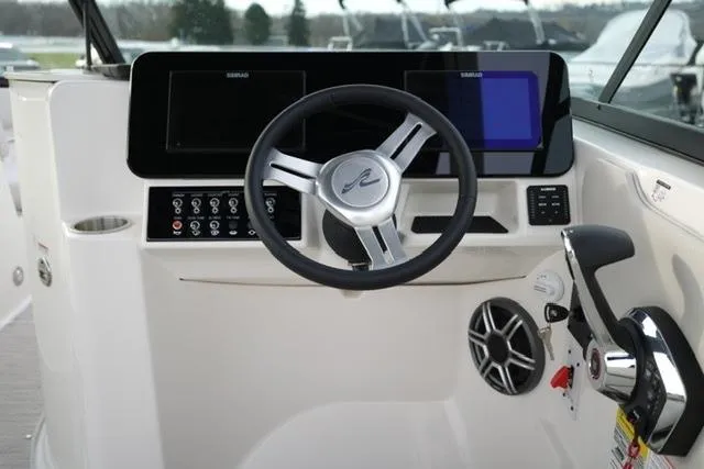 Slide: The Image of 2026 Sea Ray SDX 230 boat dashboard with steering wheel and control panel. - 15