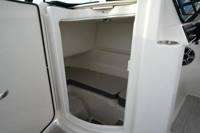 Slide: The Image of Interior cabin of 2026 Sea Ray SDX 230 boat, featuring seating and storage space. - 17