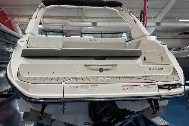 Slide: The Image of 2026 Sea Ray SDX 230 boat on trailer, blue hull, parked outdoors. - 3