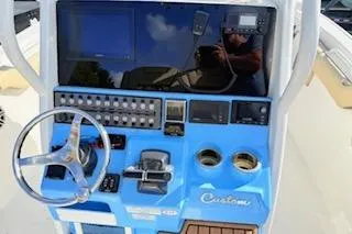 Slide: The Image of 2021 Tidewater 272 CC Adventure boat dashboard with steering wheel and controls. - 11