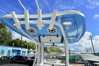 Slide: The Image of 2021 Tidewater 272 CC Adventure boat with blue T-top and rod holders. - 14