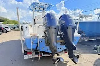 Slide: The Image of 2021 Tidewater 272 CC Adventure boat with dual outboard motors, docked under a clear sky. - 4