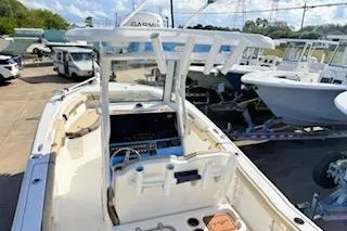 Slide: The Image of 2021 Tidewater 272 CC Adventure boat, docked with other vessels, featuring a central console. - 6