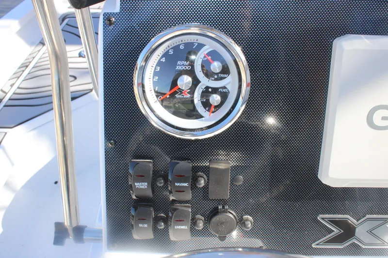 Slide: The Image of Dashboard of 2026 Xpress H20B Bay boat with RPM gauge and control switches. - 12