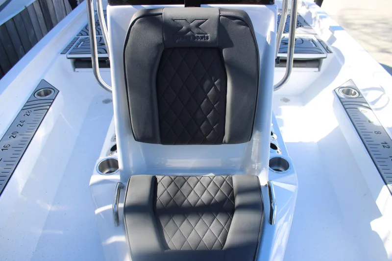 Slide: The Image of 2026 Xpress H20B Bay boat interior with black diamond-stitched seats and built-in measuring rulers. - 16