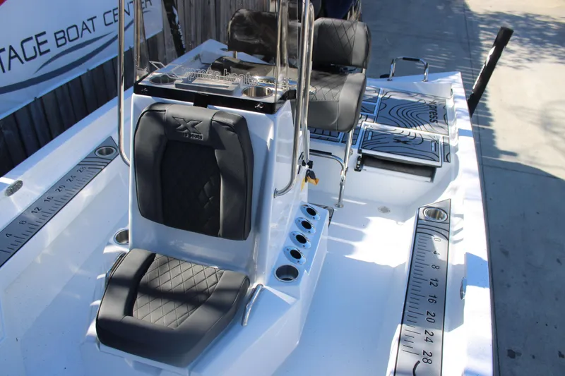 Slide: The Image of 2026 Xpress H20B Bay boat interior with black seating and measurement markings. - 24