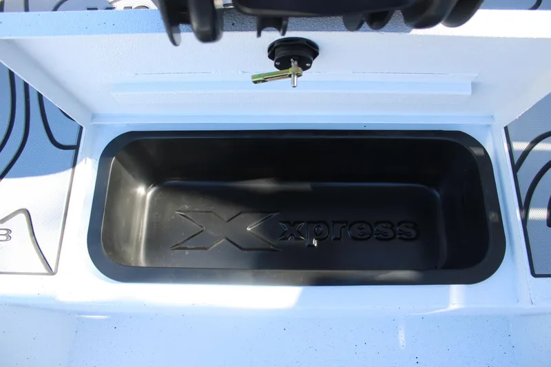 Slide: The Image of 2026 Xpress H20B Bay boat storage compartment with logo, open lid view. - 26
