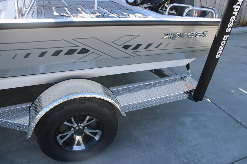 Slide: The Image of 2026 Xpress H20B Bay boat on a trailer with diamond plate fender. - 28