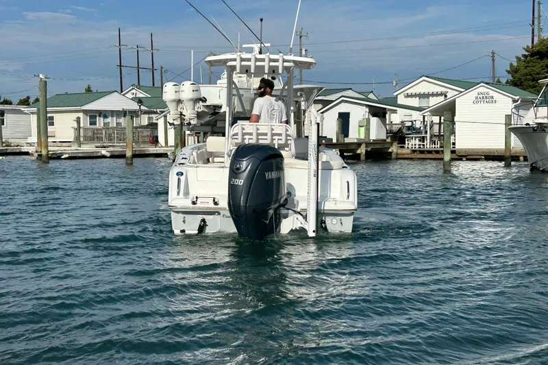 Slide: The Image of 2025 Sea Hunt Ultra 229 boat with Yamaha engine in a marina setting. - 12