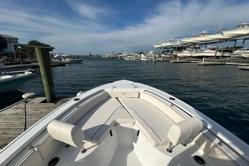 Slide: The Image of 2025 Sea Hunt Ultra 229 boat docked at marina with clear skies. - 14