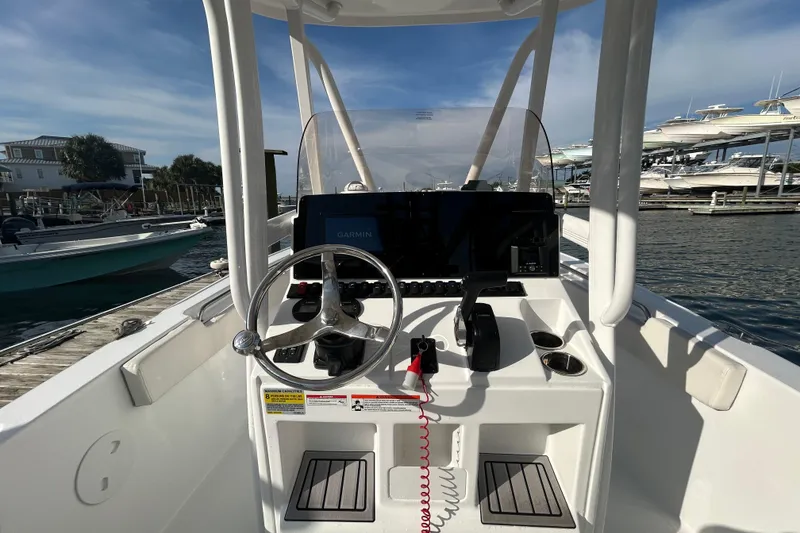 Slide: The Image of 2025 Sea Hunt Ultra 229 boat console with steering wheel and Garmin display. - 17