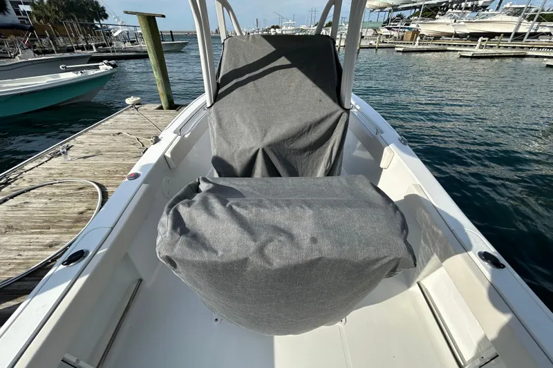 Slide: The Image of 2025 Sea Hunt Ultra 229 boat with covered seating at a marina dock. - 29