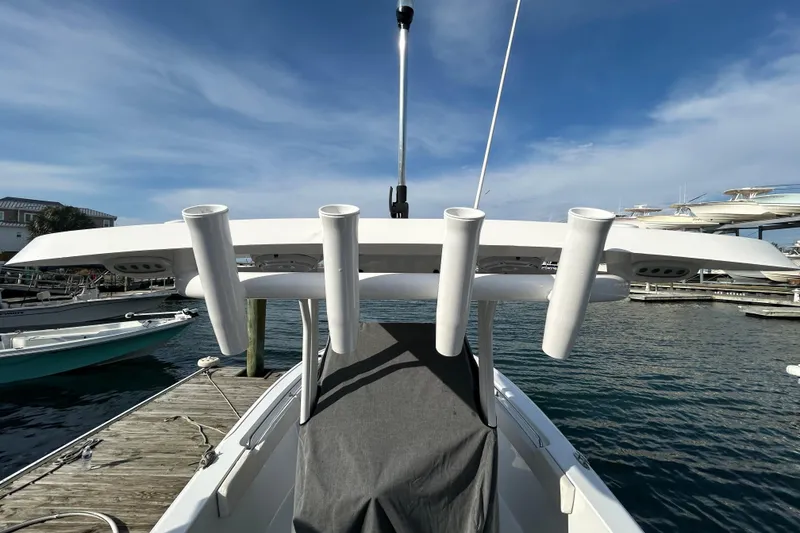 Slide: The Image of 2025 Sea Hunt Ultra 229 boat docked, featuring rod holders and a clear blue sky. - 30