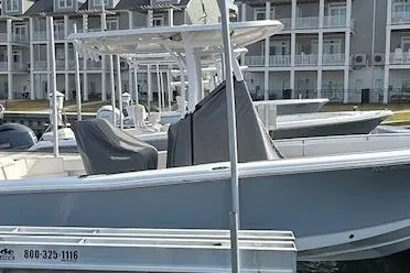 Slide: The Image of 2025 Sea Hunt Ultra 229 boat docked near waterfront cottages. - 4