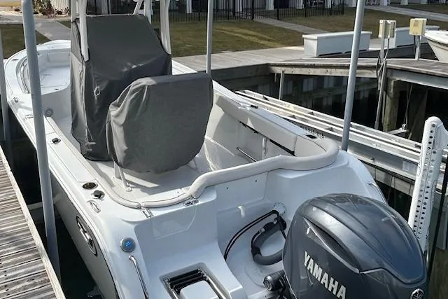 Slide: The Image of 2025 Sea Hunt Ultra 229 boat docked near coastal cottages. - 5