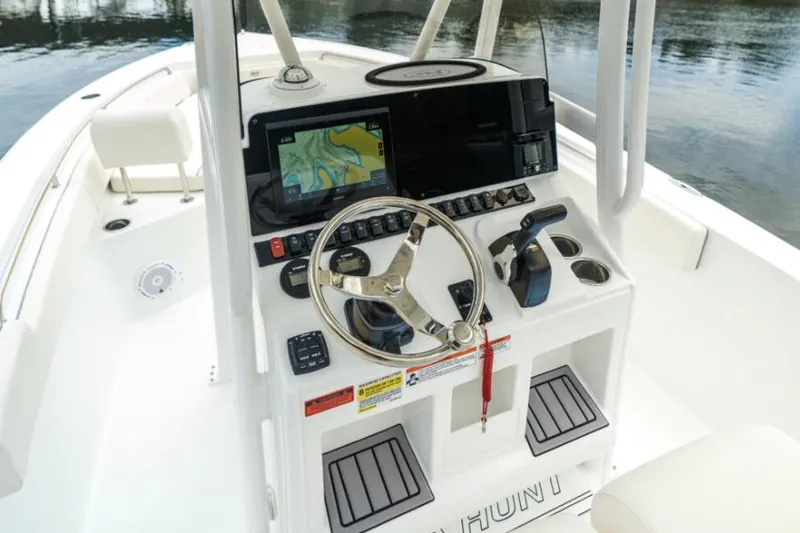 Slide: The Image of 2025 Sea Hunt Ultra 229 boat cruising in a marina with clear skies. - 6